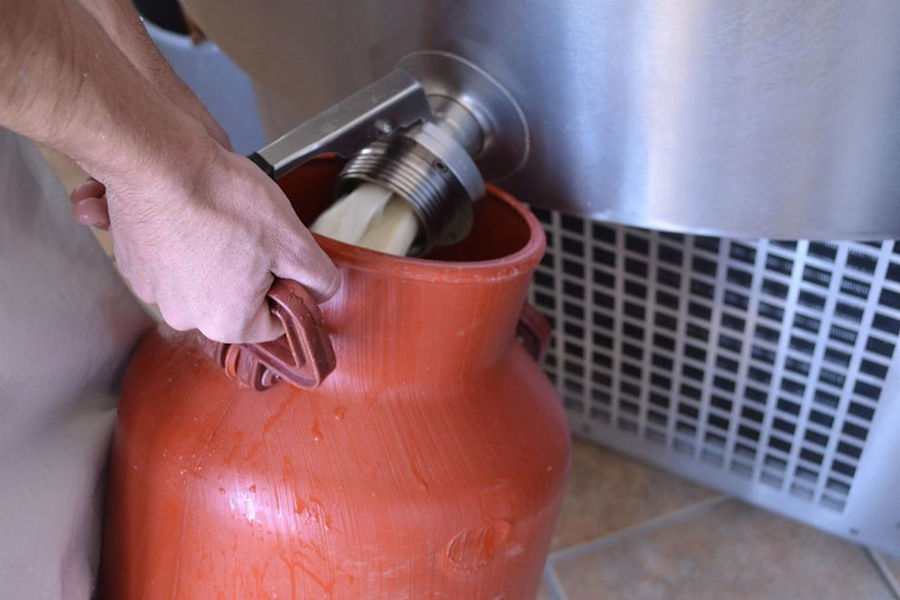 man filled a gallon of milk from dairy tank at 'Vasilas Dairy' plant